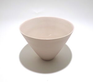 Viewed from a slight angle above, a very fine medium soft pink conical porcelain bowl, glazed on the inside with outside unglazed, available in Woburn Mosaic, contemporary art gallery