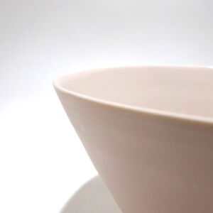 Viewed from angle above, a close-up of a very fine medium soft pink conical porcelain bowl, glazed on the inside with outside unglazed, available in Woburn Mosaic, contemporary art gallery